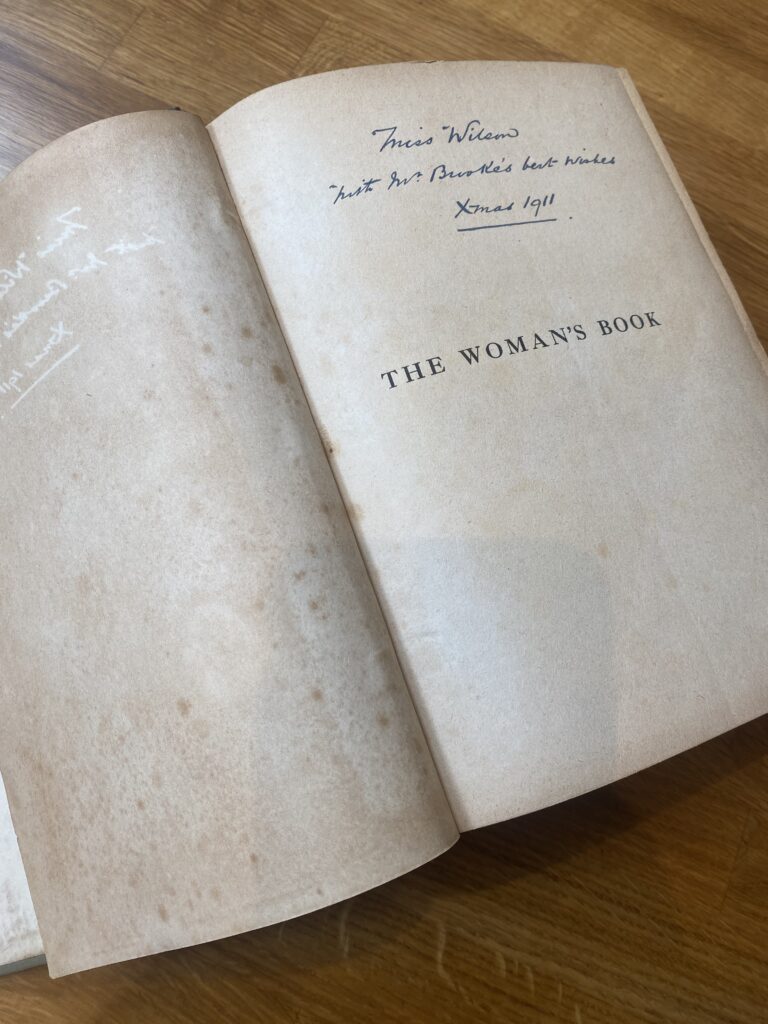 A photo of the inside cover of The Woman's Book, with an inscription to 